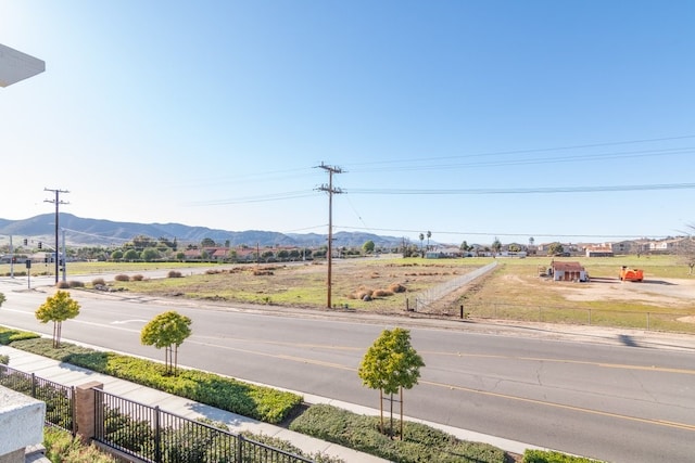 view of road featuring sidewalks, a mountain view, and curbs