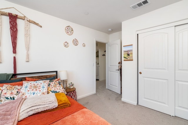 bedroom with light carpet, a closet, visible vents, and baseboards