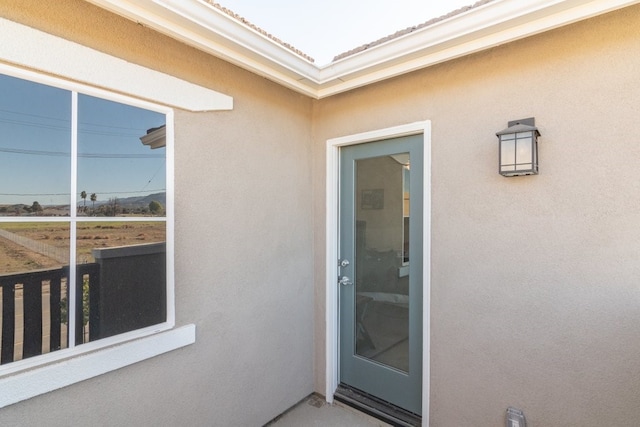 view of exterior entry featuring a tile roof and stucco siding