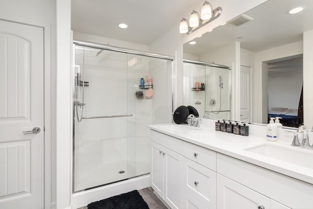 bathroom featuring ensuite bath, a shower stall, visible vents, and a sink