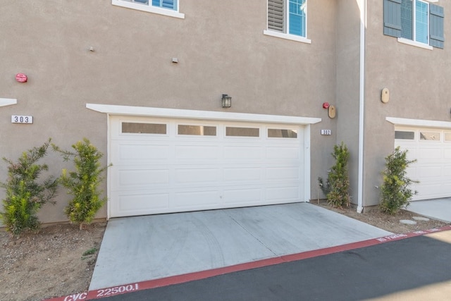 garage featuring concrete driveway