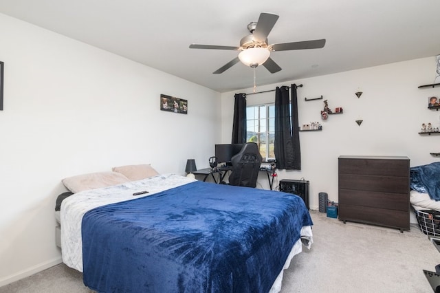 carpeted bedroom with ceiling fan and baseboards