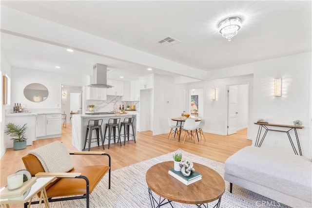 living area featuring recessed lighting, visible vents, and light wood finished floors