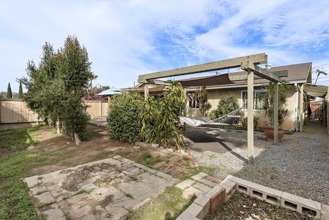 exterior space with a patio area, fence, and stucco siding