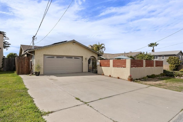 view of front of property featuring an attached garage, a fenced front yard, concrete driveway, and stucco siding