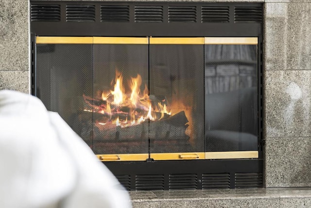 exterior details with a lit fireplace and stucco siding