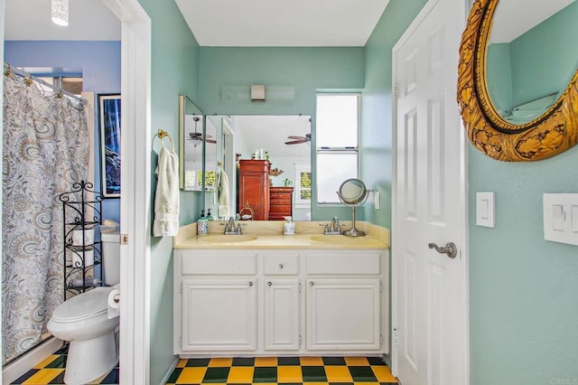 bathroom featuring double vanity, a sink, toilet, and tile patterned floors