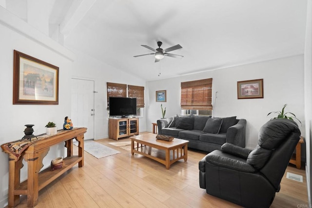 living room featuring lofted ceiling, light wood-type flooring, visible vents, and a ceiling fan