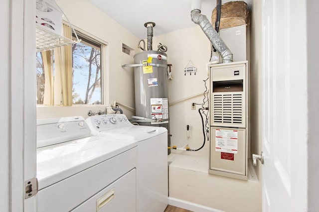 laundry area featuring washer and dryer, laundry area, and strapped water heater