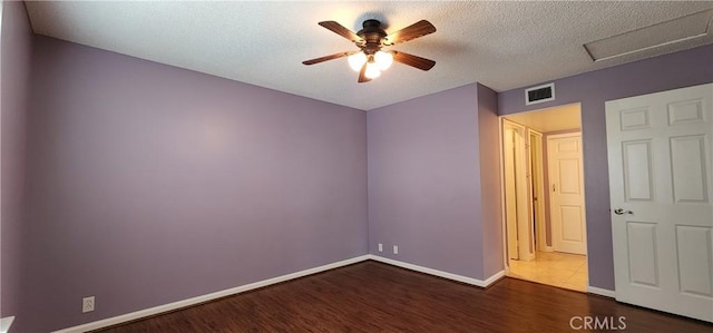 unfurnished room featuring baseboards, visible vents, a ceiling fan, wood finished floors, and a textured ceiling