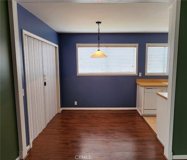 unfurnished dining area featuring baseboards, a wealth of natural light, and light wood-style floors