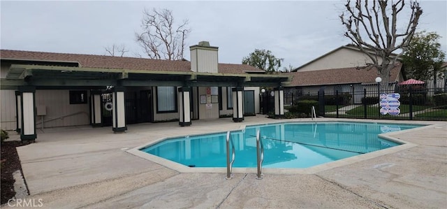 community pool featuring fence and a patio