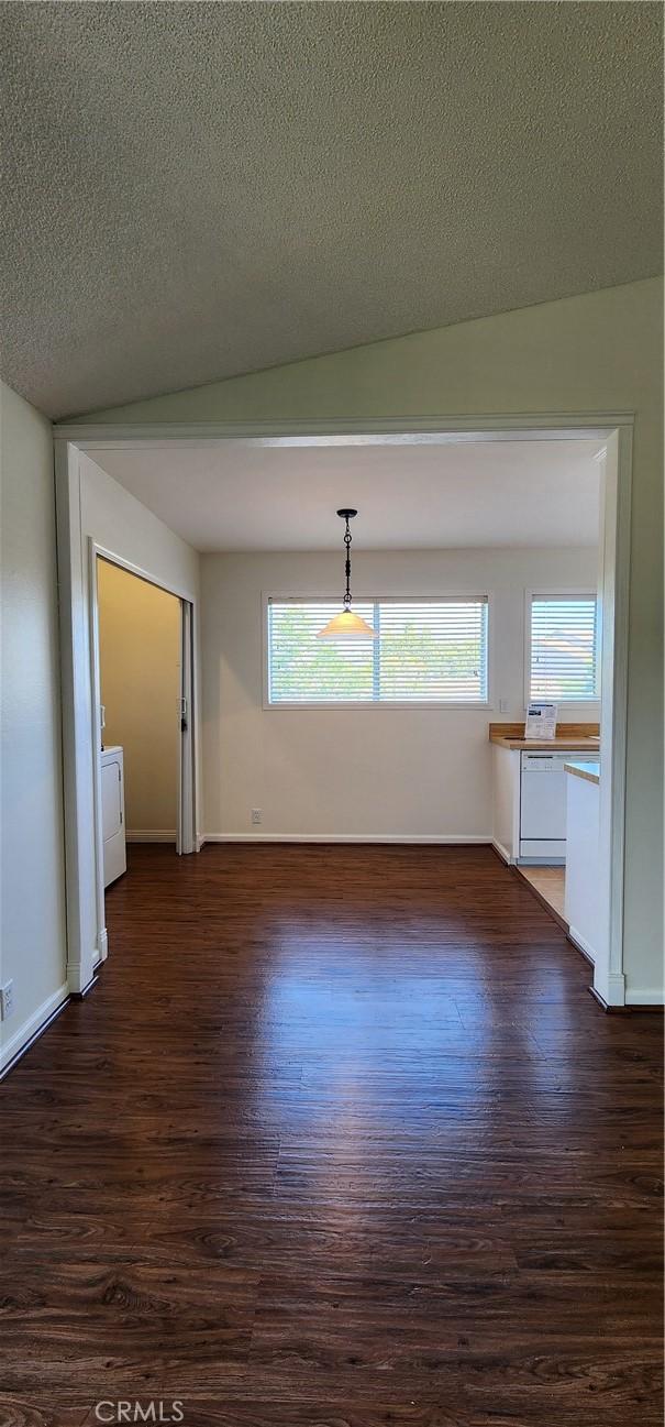 23230 Orange Ave Unit 2, Lake Forest, CA 92630 - unfurnished dining area with dark wood-style floors, washer / clothes dryer, healthy amount of natural light, and a textured ceiling