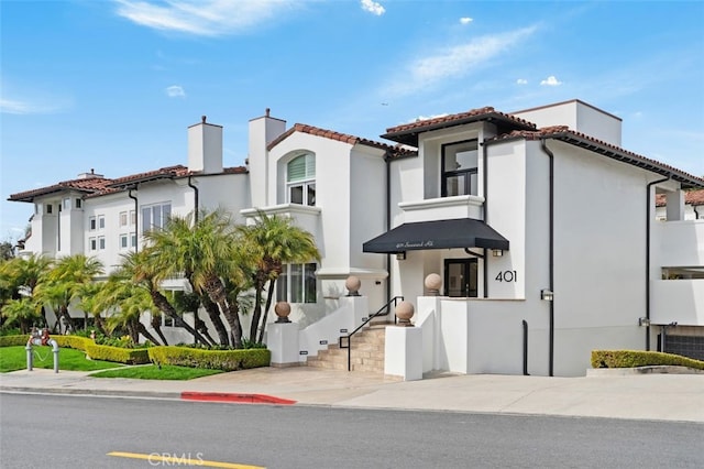 mediterranean / spanish house with a tiled roof and stucco siding