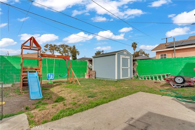 exterior space featuring a playground, an outdoor structure, fence, a storage unit, and a patio area