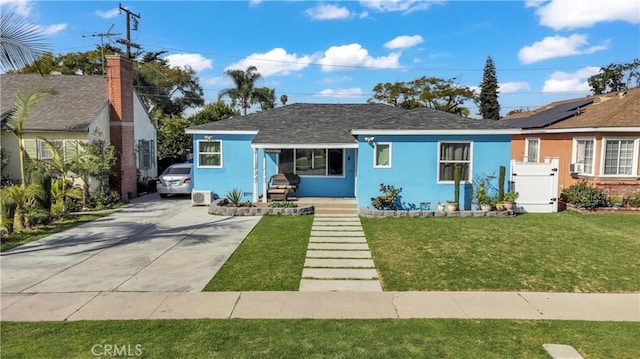 view of front of property featuring concrete driveway, a front yard, and stucco siding