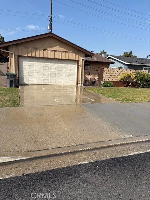 ranch-style home featuring a garage, driveway, and fence