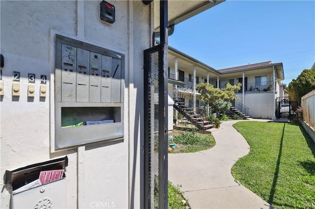 exterior space with a lawn, fence, and stairway
