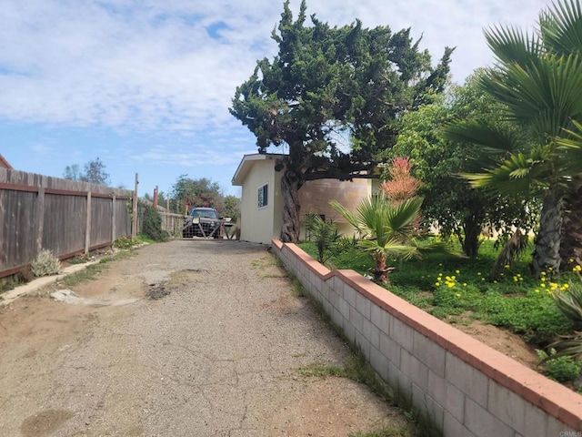 exterior space with driveway, fence, and stucco siding