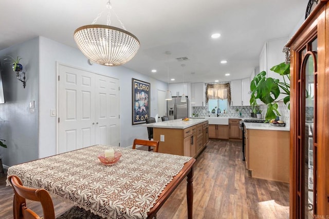 kitchen featuring dark wood-style floors, light countertops, appliances with stainless steel finishes, and a center island