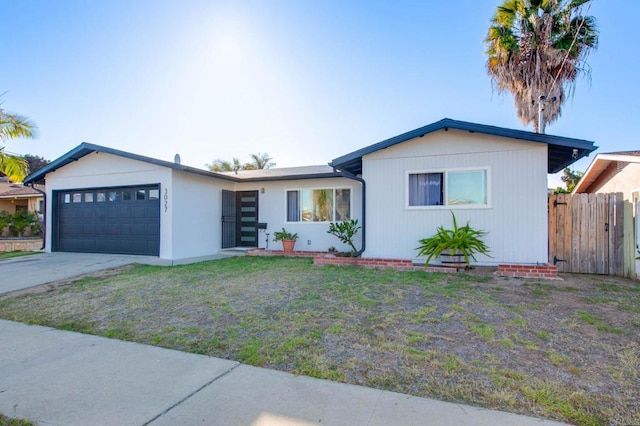 single story home with a garage, fence, a front lawn, and concrete driveway