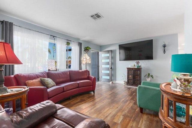 living area featuring visible vents, baseboards, and wood finished floors