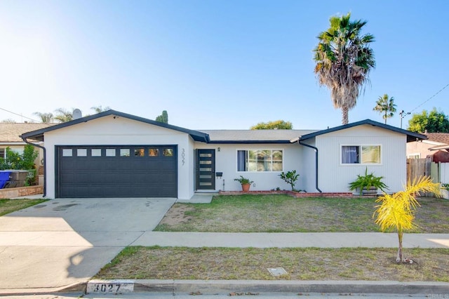 view of front of home featuring a garage, concrete driveway, a front lawn, and fence