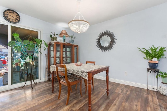 dining room featuring baseboards, wood finished floors, and a notable chandelier