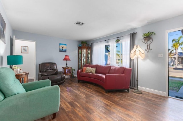 living area featuring dark wood-style floors, visible vents, and baseboards