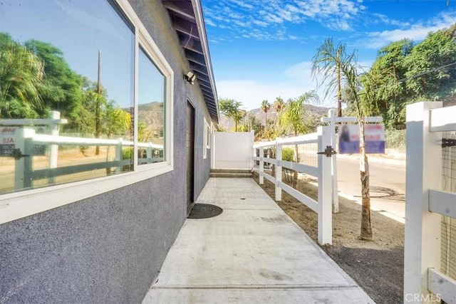 view of home's exterior with fence, a gate, and stucco siding