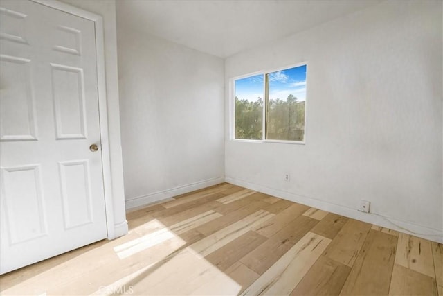 empty room featuring wood finished floors and baseboards