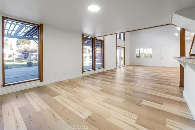 unfurnished living room featuring light wood-style floors and baseboards