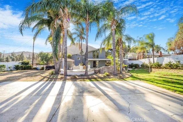 modern home featuring a patio area, a front yard, and fence