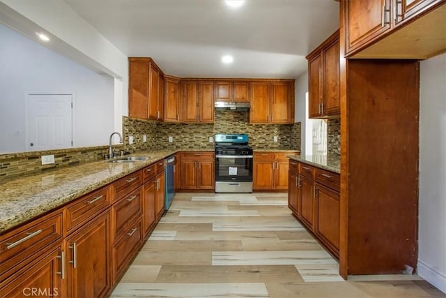 kitchen featuring appliances with stainless steel finishes, backsplash, a sink, and under cabinet range hood