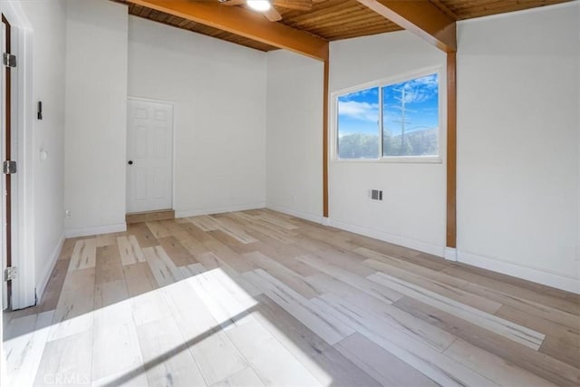 spare room featuring light wood finished floors, visible vents, lofted ceiling with beams, wood ceiling, and baseboards