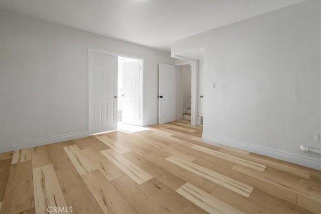 spare room featuring light wood-style flooring and baseboards