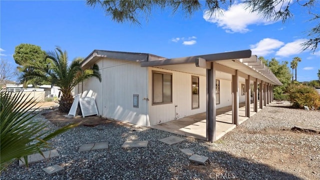 view of home's exterior with a patio area and fence