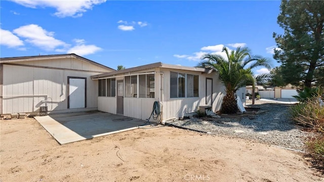 rear view of property featuring a sunroom and a patio