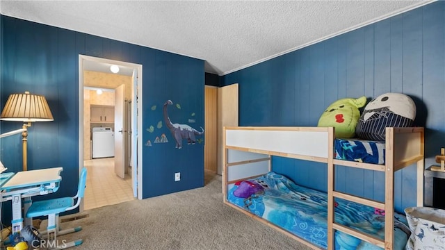 bedroom featuring washer / dryer, carpet, and a textured ceiling