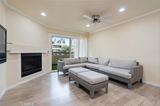 living room with light wood-style flooring and crown molding