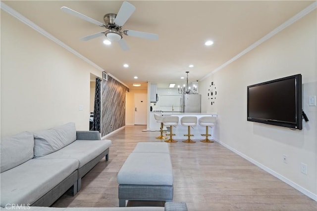 living area with ornamental molding, light wood-type flooring, baseboards, and recessed lighting