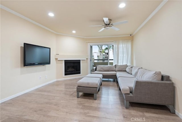 living room with light wood-style floors, crown molding, and baseboards