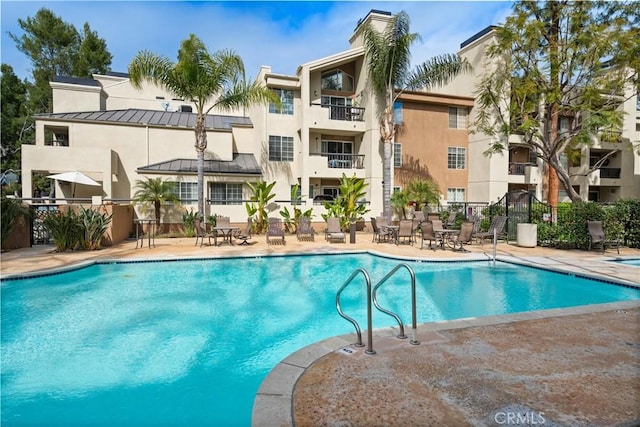 community pool featuring a patio area and fence