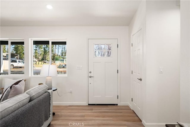 entryway with light wood-type flooring, baseboards, and recessed lighting