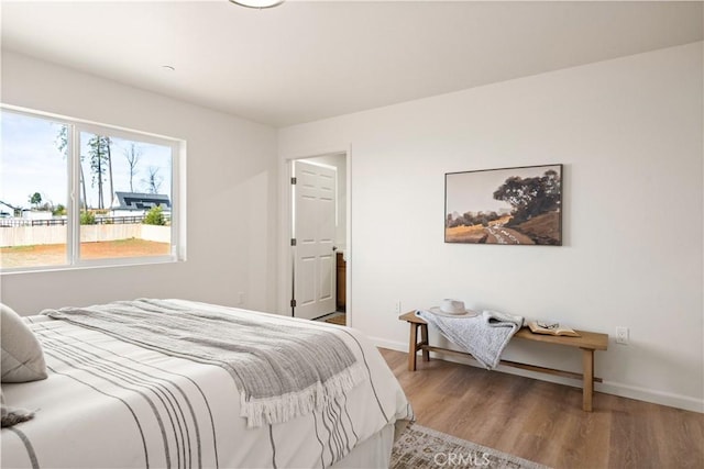 bedroom with wood finished floors and baseboards