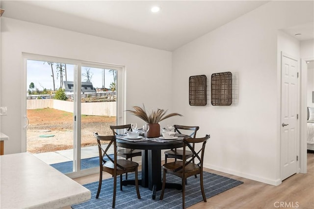 dining area featuring light wood finished floors, baseboards, and recessed lighting