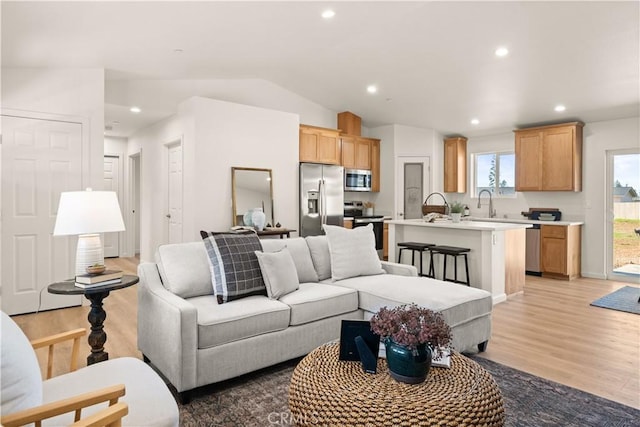 living area with light wood finished floors, vaulted ceiling, and recessed lighting