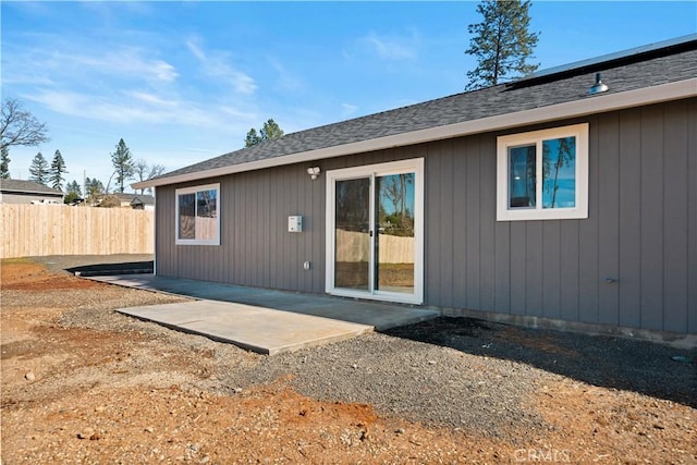 back of house featuring a patio area, fence, and roof with shingles