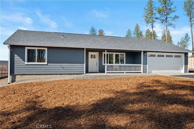 ranch-style house featuring a garage, covered porch, a shingled roof, and concrete driveway