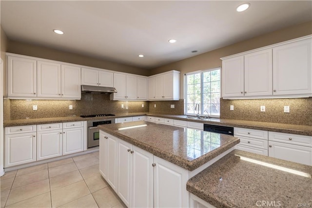 kitchen with oven, a sink, under cabinet range hood, and white cabinetry